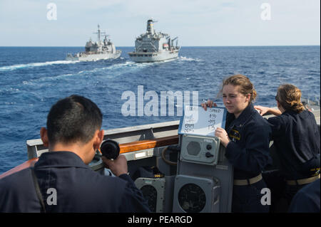 151122-N-UF 697-015 GEWÄSSER SÜDLICH VON JAPAN (Nov. 22, 2015) Ens. Savannah R. Stafford, und die uns zugewiesen - Einsatz der Arleigh-Burke-Klasse Lenkwaffen-zerstörer USS Stethem (DDG63), markiert den Kurs und die Geschwindigkeit in der Vorbereitung für ein unterwegs-Auffüllung mit der Flotte Auffüllung Öler USNS Tippecanoe (T-AO 199) während der jährlichen Übung (AE) 16 Während die Ticonderoga-Klasse geführte-missile Cruiser USS Antietam (CG62) gesehen wird. Stethem beteiligt sich an AE 16 Interoperabilität zwischen japanischen und amerikanischen Streitkräfte durch die Ausbildung in der Luft und auf See zu erhöhen. (U.S. Marine p Stockfoto