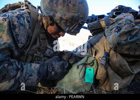 Cpl. Zachary Mendiola, ein Port Orchard, Washington, native und eine Landung Support Specialist mit Combat Logistik Bataillon 11, gilt ein stauschlauch bei einem simulierten Unfall während des grundlegenden Kampffertigkeiten Kurs an Bord Marine Corps Base Camp Pendleton, Calif., Nov. 20, 2015. BCSC dient als refamiliarization Kurs für Nicht-infanterie Marines, der Vermittlung der grundlegenden Fähigkeiten, die benötigt werden, um in einem Kampfgebiet zu betreiben. (U.S. Marine Corps Foto von Lance Cpl. Devan K. Gowans/Freigegeben) Stockfoto