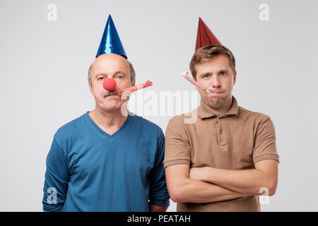 Unglücklich Jungs sind auf der Geburtstagsparty. Sohn und Vater sind verärgert und wollen nicht um Spaß zu haben. Lassen Sie uns versuchen, glücklich zu werden. Stockfoto