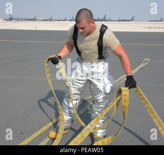 Ein 379 Bauingenieur Squadron Feuerwehrmann arbeiten, die auf einem Feuerwehrschlauch nach einer Übung im Al Udeid Air Base, Katar, 20. Die Übung empfohlene einen simulierten Brand auf einem KC-135 Stratotanker und erforderliche Feuerwehrmänner einen Verletzten, Mitglied der Besatzung zu retten. Innerhalb von Minuten, mehrere Feuerwehrmänner kletterte auf den linken Flügel des Flugzeugs, in das Flugzeug und zog den verletzten Air Crew Mitglied in Sicherheit. Übungen helfen Ersthelfer behalten ihre Skillsets. (U.S. Air Force Foto von Tech. Sgt. James Hodgman / freigegeben) Stockfoto