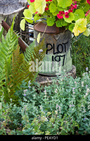 Zuteilung Grundstück Nummer auf der Seite einer alten Metall Bewässerung geschrieben werden kann. Die Dose ist auch als Garten Pflanzmaschine verwendet. Stockfoto