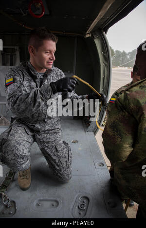 Eine kolumbianische Jumpmaster führt jumpmaster Aufgaben an Bord eines UH-60 Black Hawk bei Einarbeitung zur Unterstützung der Operation Spielzeug Tropfen an Simmons Army Airfield, Cumberland County, N.C., zur Unterstützung der Operation Spielzeug Drop Dez. 1, 2015. Betrieb Spielzeug Drop kombiniert U.S. Army Reserve Personal, Armee Fallschirmjäger, Dutzende von Freiwilligen und Partner Nation militärisches Personal, mehr als ein Dutzend Luftwaffe und Spielzeug, für das, was der weltweit größten kombinierten Betrieb geworden ist. (U.S. Armee Foto von SPC. Tracy McKithern/Freigegeben) Stockfoto