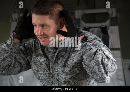 Eine kolumbianische Jumpmaster führt jumpmaster Aufgaben an Bord eines UH-60 Black Hawk bei Einarbeitung zur Unterstützung der Operation Spielzeug Tropfen an Simmons Army Airfield, Cumberland County, N.C., zur Unterstützung der Operation Spielzeug Drop Dez. 1, 2015. Betrieb Spielzeug Drop kombiniert U.S. Army Reserve Personal, Armee Fallschirmjäger, Dutzende von Freiwilligen und Partner Nation militärisches Personal, mehr als ein Dutzend Luftwaffe und Spielzeug, für das, was der weltweit größten kombinierten Betrieb geworden ist. (U.S. Armee Foto von SPC. Tracy McKithern/Freigegeben) Stockfoto