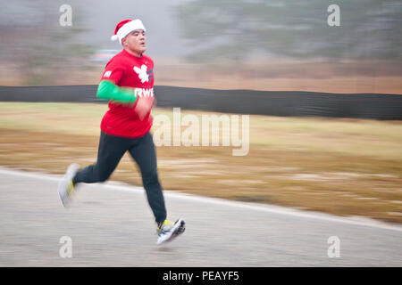 Armee Sgt. Ken Tubilleja, ein Soldat von C Company, 407 Brigade Support Battalion, 82nd Airborne Brigade, Sprints, um die Ziellinie von der Luftwaffe Spielzeug Trab Rennen 5K. Das Spielzeug Trab ist Teil des 18. jährlichen Randy Oler Memorial Betrieb Spielzeug Trab, von der US-Armee die zivilen Angelegenheiten & psychologische Operations Command (Airborne), Dez. 2, 2015 gehostet, an Papst Feld, N.C. Betrieb Spielzeug Drop ist der weltweit größte kombinierten Betrieb mit sieben Partner nation Fallschirmjäger teilnehmenden und Soldaten erlaubt, die Möglichkeit, Kindern in Not zu helfen, überall Spielwaren für den Urlaub erhalten. Stockfoto