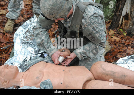 Spc. Anthony Macaione, 68 W Combat Medic an der 82nd Airborne Division Artillerie zugewiesen, gilt ein Stauschlauch an den Arm der simulierten Unfall während der medizinischen Evakuierung Schulung in Fort Bragg, N.C., Dez. 1, 2015. Er prepped Die verletzten Soldaten für die Evakuierung, um die Chancen des Überlebens während der Goldenen Stunde zu erhöhen. (Capt. Joe Bush, 82nd Airborne DIVARTY/freigegeben.) Stockfoto