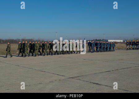 DEVESELU, Rumänien (31. 03, 2015) - Rumänisch Service Mitglieder der Rumänischen 99th Military Base und Segler auf Naval Support Facility Deveselu, Rumänien stationiert zugeordnet Verhalten eine Pass-in-review während einer rumänischen Battle Flag Zeremonie und Ändern des Befehls in Deveselu, Rumänien Dez. 3, 2015. Eine rumänische Battle Flag wird nur einmal an eine militärische Einheit erteilt, und es muss verdient werden. Die Fahne symbolisiert die Einheit und ist Vertreter der harten Arbeit, die die Einheit und Exzellenz. (U.S. Marine Foto von Mass Communication Specialist 3. Klasse Weston Jones/Freigegeben) Stockfoto