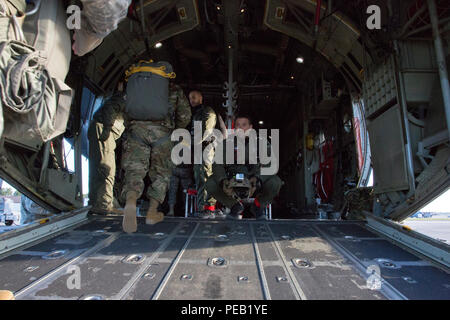 Niederländische Sgt. Maj. Alessandra Kievith, jump Master, Recht, Uhren, USA Armee Fallschirmjäger gehen Sie auf der C-130 Hercules zur Unterstützung der Operation Spielzeug Fallen, Fort Bragg, N.C., Dez. 4, 2015. Betrieb Spielzeug Drop kombiniert U.S. Army Reserve Personal, Armee Fallschirmjäger, Dutzende von Freiwilligen und Partner Nation militärisches Personal, mehr als ein Dutzend Luftwaffe und Spielzeug, für das, was der weltweit größten kombinierten Betrieb geworden ist. (U.S. Armee Foto von SPC. Tracy McKithern/Freigegeben) Stockfoto