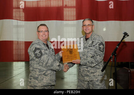 Us Air Force Chief Master Sgt. Timothy Roberts, 145 Instandhaltungsgruppe (Mxg), erhält eine Plakette vom Chief Master Sgt. David Stafford, 145 MXG, gratulieren ihm zu seiner Beförderung während einer Zeremonie in seiner Ehre auf der North Carolina Air National Guard Base, Charlotte Douglas International Airport, Dez. 5, 2015 statt. Roberts Soldat in der US Air Force im Januar 1983 und ist jetzt der Qualitätssicherung Betriebsleiter für seine Einheit. (U.S. Air National Guard Foto: Staff Sgt. Julianne M. Showalter, 145 Öffentliche Angelegenheiten/Freigegeben) Stockfoto