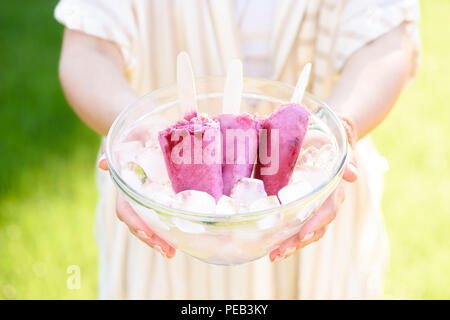 Frau mit Schale mit Berry ice Pops Stockfoto