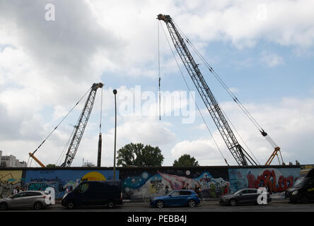 14. August 2018, Berlin, Deutschland: baukräne stehen hinter der East Side Gallery an der Spree. Es gibt Pläne, ein Hotel und Wohnungen zu bauen. Foto: Paul Zinken/dpa Stockfoto