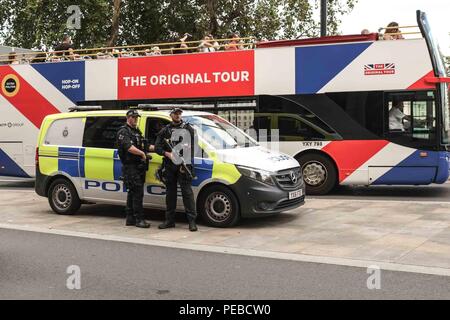 London, 14. August 2018. Eine London Sightseeing Bus fährt bewaffnete Polizei neben Westminster Bridge nach einem Terror Vorfall, wo ein Mann, der ein Auto fährt in Sicherheit Sperren außerhalb des Parlaments abgestürzt. Mehrere Menschen wurden verletzt. Credit: Claire Doherty/Alamy leben Nachrichten Stockfoto