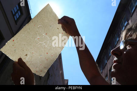 Augsburg, Deutschland. 19. Juli 2018. Klaus Wengenmayr hält handgeschöpftes Papier mit Wasserzeichen angezeigt ist ein Elephant Head vor seinem Restaurant. Das Papier Künstler und Pub Besitzer produziert handgeschöpftes Papier, die er verkauft weltweit (für dpa Sommer Serie: 'Menschen am Fluss' und die KORR', Lechwasser Elefantenkot und Schafwolle ergibt exklusives Papier" vom 15.08.2018). Foto: Karl-Josef Hildenbrand/dpa/Alamy leben Nachrichten Stockfoto