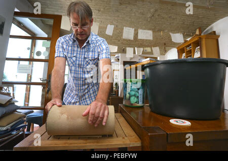 Augsburg, Deutschland. 19. Juli 2018. Klaus Wengenmayr pressen Papier Zellstoff aus einer Mehrwertsteuer in seinem Pub. Das Papier Künstler und Pub Besitzer produziert handgeschöpftes Papier, die er verkauft weltweit (für dpa Sommer Serie: 'Menschen am Fluss' und die KORR', Lechwasser Elefantenkot und Schafwolle ergibt exklusives Papier" vom 15.08.2018). Foto: Karl-Josef Hildenbrand/dpa/Alamy leben Nachrichten Stockfoto