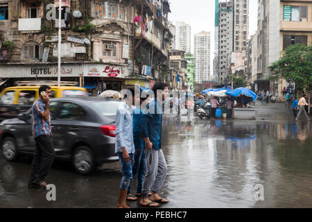 Fußgänger und den Verkehr auf der Straße nach dem Monsun Regenguß in der Grant Road, Mumbai, Indien Stockfoto