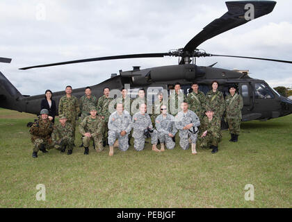 Soldaten aus der Armee finden Engagement Team-Japan (ARET-J) melden Sie Japan Masse Selbstverteidigung finden Komponente Kandidaten und Service Mitglieder für ein Gruppenfoto vor einem UH-60 Black Hawk Hubschrauber 19.11.2015, am Lager Takeyama, Japan. ARET-J mit US-Armee Japan Aviation Battalion neun JGSDF finden Kandidaten aus den 117 Ausbildung Bataillon Hauptsitz in Camp Takeyama, Japan, zum Hauptquartier der US-Armee Japan im Camp Zama, Japan Verkehr koordiniert, im Rahmen eines bilateralen Air Mission, dass die JGSDF Kandidaten für die Mission, die Kultur und die Fähigkeiten ihrer in den USA eingeführt Stockfoto