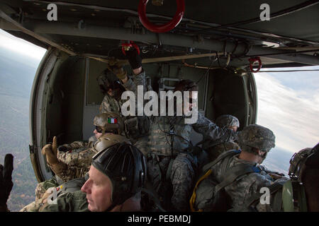 Us-Kanadischen, Italienisch und kolumbianischen Fallschirmjäger an Airborne Operationen an Bord eines UH-60 Black Hawk zur Unterstützung der Operation Spielzeug Fallen, Fort Bragg, N.C., Dez. 3, 2015. Betrieb Spielzeug Drop kombiniert U.S. Army Reserve Personal, Armee Fallschirmjäger, Dutzende von Freiwilligen und Partner Nation militärisches Personal, mehr als ein Dutzend Luftwaffe und Spielzeug, für das, was der weltweit größten kombinierten Betrieb geworden ist. (U.S. Armee Foto von SPC. Tracy McKithern/Freigegeben) Stockfoto
