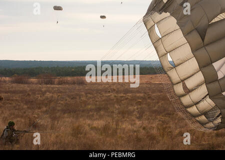 Kanadische Fallschirmjäger Cpl. Jason geknickt, von Trenton, Ontario, zeichnet in seinem Fallschirm auf der Nijmegen Landing Zone für die 18. jährlichen Randy Oler Memorial Betrieb Spielzeug fallen, durch die US-Armee die zivilen Angelegenheiten & psychologische Operations Command (Airborne) gehostet, Dez. 3, 2015 in Fort Bragg, N.C. Betrieb Spielzeug Drop ist der weltweit größte kombinierten Betrieb und kollektive Übung die Soldaten die Möglichkeit, Kindern in Not zu helfen Spielwaren für den Urlaub erhalten. Verbogene dient als rigger mit der Kanadischen Armee Advanced Warfare Center. (U.S. Armee Foto von Sgt. Schicksal Mann, 450 Civ Stockfoto