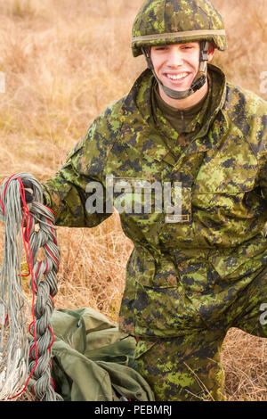 Kanadische Fallschirmjäger, Cpl. Jason geknickt, von Trenton, Ontario, packs entfernt sein Fallschirm nach erfolgreichem Abschluss einen Sprung auf den Nijmegen Landing Zone für die 18. jährlichen Randy Oler Memorial Betrieb Spielzeug Fallen, bewirtet durch die US-Armee die zivilen Angelegenheiten & psychologische Operations Command (Airborne), Dez. 3, 2015 in Fort Bragg, N.C. Betrieb Spielzeug Drop ist der weltweit größte kombinierten Betrieb und kollektive Übung die Soldaten die Möglichkeit, Kindern in Not zu helfen Spielwaren für den Urlaub erhalten. Verbogene dient als rigger mit der Kanadischen Armee Advanced Warfare Center. (U.S. Ar Stockfoto