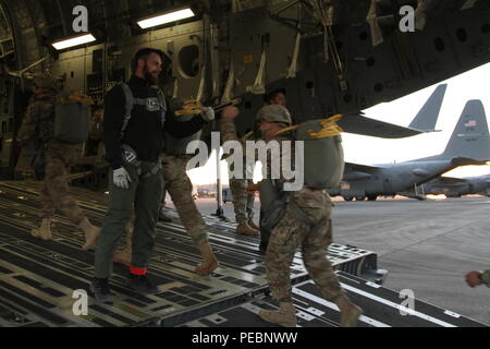 Niederländische Jumpmaster Sgt. 1. Klasse Niels van Gestel grüßt ein Fallschirmjäger, als er Boards das Flugzeug während des Betriebs Spielzeug Fallen, Fort Bragg, N.C., Dez. 5, 2015. Betrieb Spielzeug Drop ist der weltweit größte kombinierten Betrieb mit sieben Partner - nation Fallschirmjäger teilnehmenden und Soldaten erlaubt, die Möglichkeit, Kindern in Not zu helfen, überall Spielwaren für den Urlaub erhalten. (U.S. Armee Foto von SPC. Josephine Carlson) Stockfoto