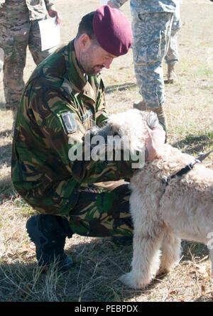 Niederlande jumpmaster Sgt. Maj. Alessandra Veivith (links) nimmt sich Zeit für Hund eines Soldaten, Charlie, nach seinem Abstieg auf Sizilien Drop Zone in Fort Bragg, N.C., Dez. 5, 2015. "Springen Tag' ist die zweite von zwei Tage in der 18. jährlichen Randy Oler Memorial Betrieb Spielzeug Fallen, bewirtet durch die US-Armee die zivilen Angelegenheiten & psychologische Operations Command (Airborne). Stockfoto