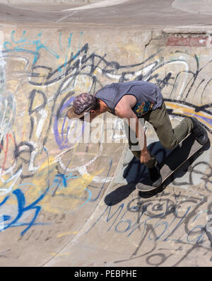 Junger Mann Skateboarder im Riverside River Yard Skateboard Bowl, tolle Herbst, Montana, USA Stockfoto