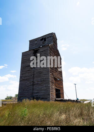 Ein altes, heruntergekommenes, beschädigte hölzerne Getreidesilo in ländlichen Montana von einem niedrigen Winkel fotografiert. Stockfoto