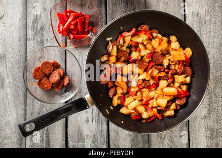 Tortilla de patatas. Kochen spanisches Omelette mit Chorizo Wurst, Kartoffeln, Paprika in die Pfanne. Spanische Küche. Ansicht von oben. Stockfoto