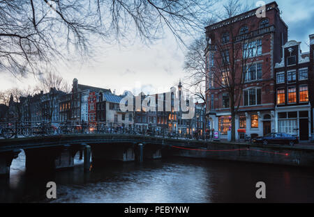 Amsterdam, Niederlande, 26. Dezember 2017: Brücke über den Kanal Herengracht, im Hintergrund der Turm der Westerkerk in der Altstadt. Stockfoto