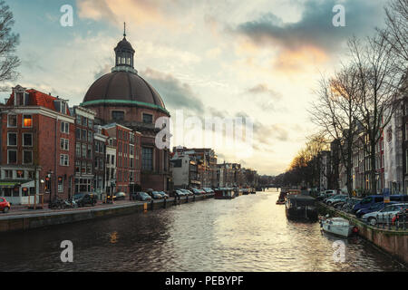 Amsterdam, Niederlande, 26. Dezember 2017: Die Kuppel der Kirche entlang der Singel Kanal im Zentrum von Amsterdam bei Sonnenuntergang Stockfoto