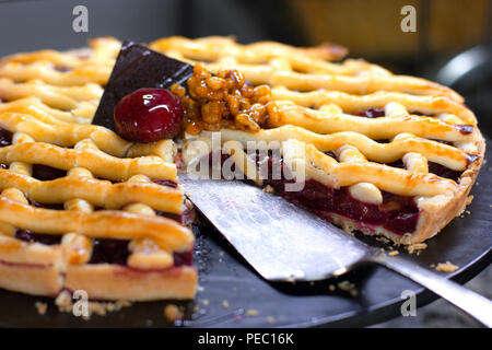 Torte mit Himbeeren, mit frischen Erdbeeren dekoriert, auf schwarzem Hintergrund Stockfoto