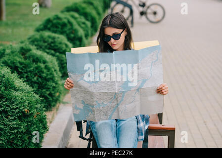 Junge Frau Traveler in Sonnenbrille holding Karte Stockfoto