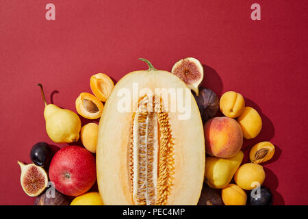 Blick von oben auf die verschiedenen Frische reife süße Früchte auf rotem Hintergrund Stockfoto