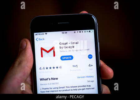 Hand mit iPhone mit Google Gmail App im Apple App Store, E-Mail Service, Symbol der App, Anzeige auf einem Bildschirm eines Handys Stockfoto