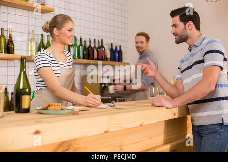In der Cafeteria. Freuen schönen hungrigen Mann stand in der Nähe des Zählers und Essen bestellen während des Aufenthalts in einer Cafeteria Stockfoto