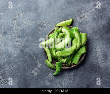 Getrocknete pomelo Slices auf grauem Beton Hintergrund. Draufsicht der kandierten Früchte Stockfoto