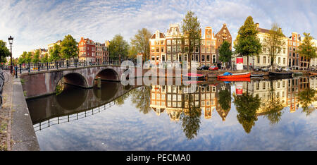 Schöne Amsterdam Sonnenuntergang. Typische alte holländische Häuser auf der Brücke und Kanäle im Frühjahr, Niederlande Stockfoto