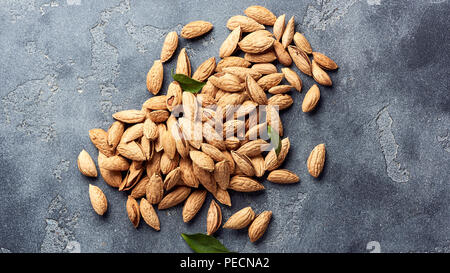 Mandeln ohne Schale auf grauem Beton Hintergrund mit kopieren. Ansicht von oben. Stockfoto