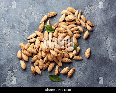 Mandeln ohne Schale auf grauem Beton Hintergrund mit kopieren. Ansicht von oben. Stockfoto