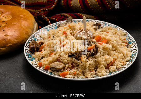 Pilav auf Platte mit orientalischen Ornament und traditionellen asiatischen Brot - churek. Plov. Stockfoto