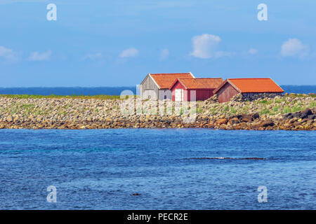 Einsame Hütten am Strand in unmittelbarer Nähe des Kvassheim Leuchtturm auf der norwegischen Südküste. Selektiver Fokus auf die Schuppen. Der Horizont ist verschwommen Stockfoto