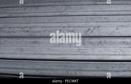 Square flat-rolled pipe metal profile in packs at the warehouse of metal products. Weathered metals profiles for construction. Metal corrosion Stockfoto