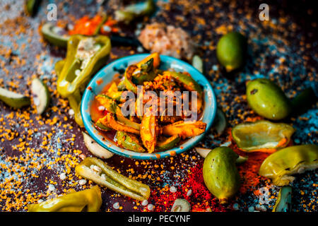 Nahaufnahme der Aam oder Kari ka ka achar achar oder traditionelle Rohstoffe Mango Pickles mit all seinen Bestandteilen und speiceis auf einer hölzernen Oberfläche in drak Gotischen col Stockfoto