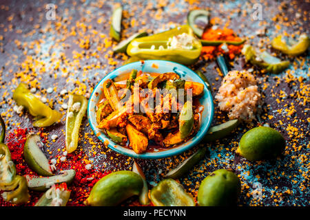 Nahaufnahme der Aam oder Kari ka ka achar achar oder traditionelle Rohstoffe Mango Pickles mit all seinen Bestandteilen und speiceis auf einer hölzernen Oberfläche in drak Gotischen col Stockfoto