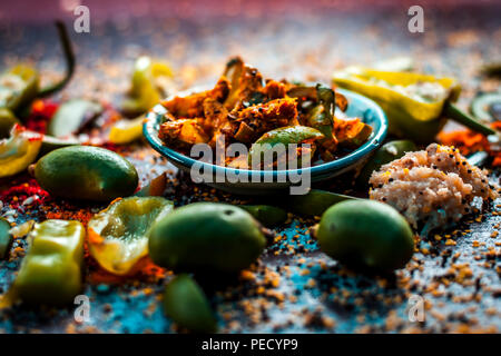 Nahaufnahme der Aam oder Kari ka ka achar achar oder traditionelle Rohstoffe Mango Pickles mit all seinen Bestandteilen und speiceis auf einer hölzernen Oberfläche in drak Gotischen col Stockfoto