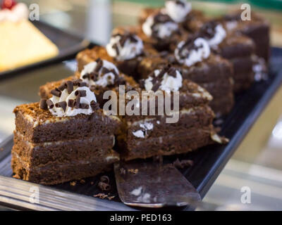 Schokoladenkuchen mit weißer Schokolade rasieren auf silbernem Tablett Stockfoto