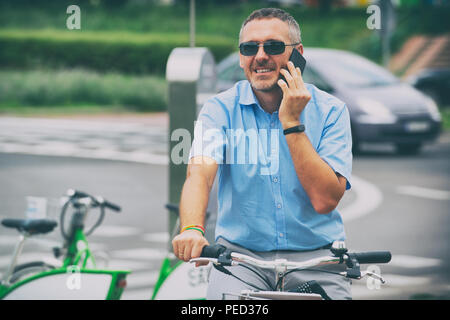 Mann mit dem Fahrrad auf dem Weg zur Arbeit, ein Konzept vor, das die Verwendung City Bike als umweltfreundliche Art der Fortbewegung zu arbeiten Stockfoto