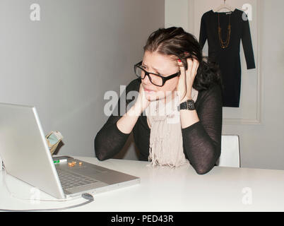 Eine junge frustrierte Frau bei der Arbeit. Stockfoto