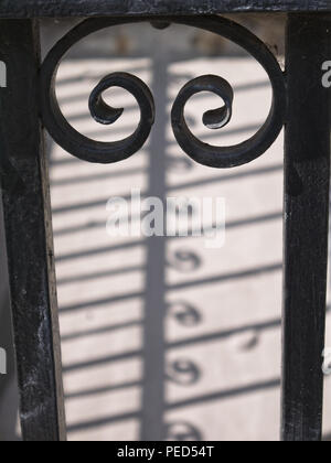 Silhouette von antiken gusseisernen Geländer mit schönen Schatten auf dem Boden. Selektiver Fokus, verschwommenen Hintergrund. Stockfoto