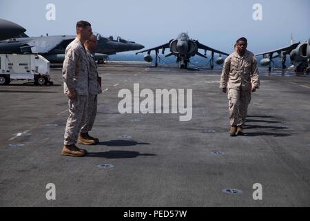 Indischer Ozean (Aug. 1, 2015) US-Marines mit der 15 Marine Expeditionary Unit Command Element März über die Flight Deck während der Werbeaktion Zeremonie an Bord der Amphibisches Schiff USS Essex (LHD2). Die 15. MEU ist auf der Essex Amphibious Ready Gruppe begonnen und bereitgestellt, um die regionale Sicherheit in den USA 5 Flotte Bereich der Betrieb aufrecht zu erhalten. (U.S. Marine Corps Foto von Cpl. Anna Albrecht/Freigegeben) Stockfoto