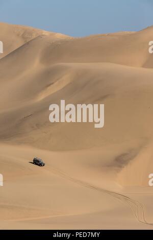 Ein Jeep fährt durch die Sanddünen in der Nähe von Sandwich Harbour in Walvis Bay. Reifenspuren sind durch andere Fahrzeuge, die über das d Laufwerk gelassen worden Stockfoto